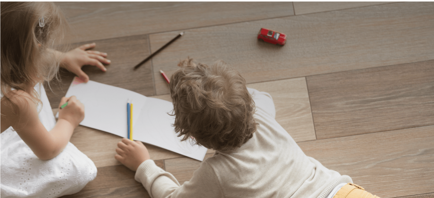 Kids drawing on notebook laying on floor | Big Bob's Flooring Outlet Birmingham